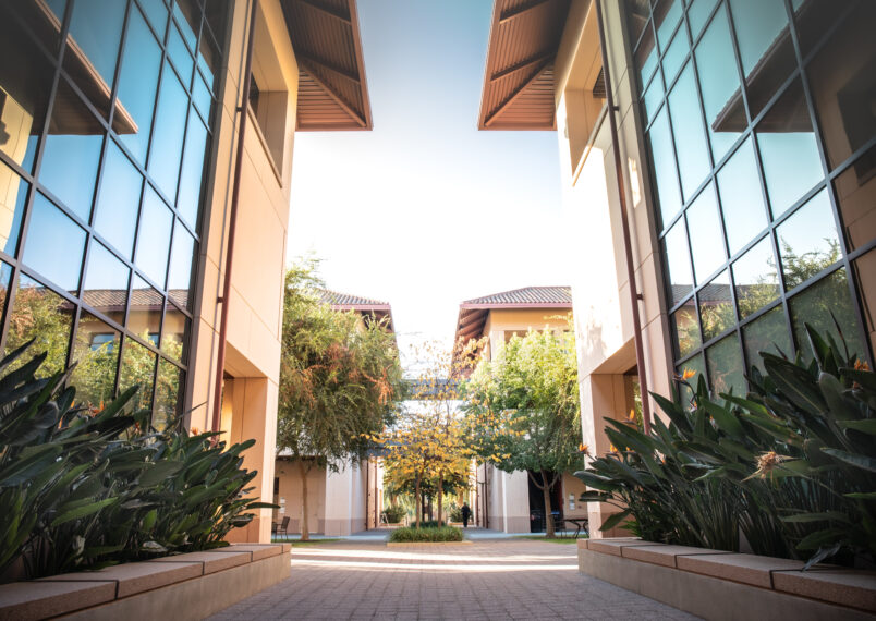 Scenic courtyard at Stanford Graduate School of Business with modern architecture and lush landscaping.